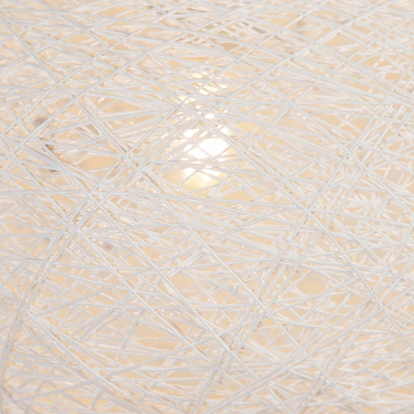 Nahaufnahme eines weißen Lampenschirms mit einem Muster aus verflochtenen Fäden und leuchtender Lichtquelle.