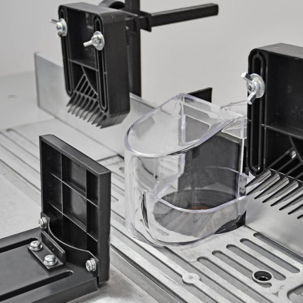 Detailansicht einer Frästischvorrichtung mit verschiedenen Anschlägen und einer transparenten Schutzhaube.