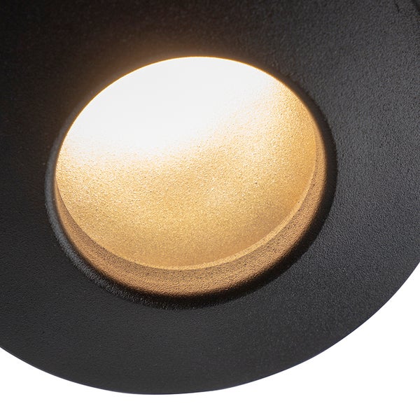 Detailaufnahme eines runden LED-Leuchtmittels mit strukturierter goldfarbener Oberfläche in einem schwarzen Rahmen.