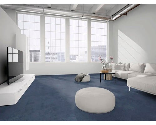 Geräumiges, helles Wohnzimmer im Industriestil mit dunkelblauem Teppichboden, weißem Sofa und großen Fensterfronten.