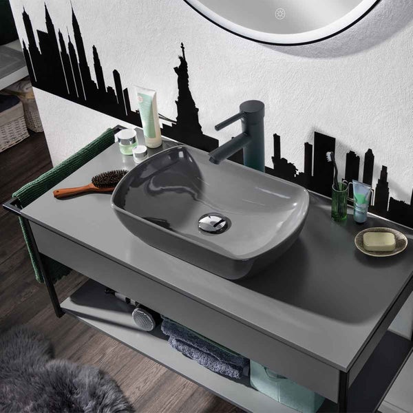 Badezimmerwaschtisch mit Aufsatzwaschbecken und Armatur vor einer Tapete mit Skyline-Motiv