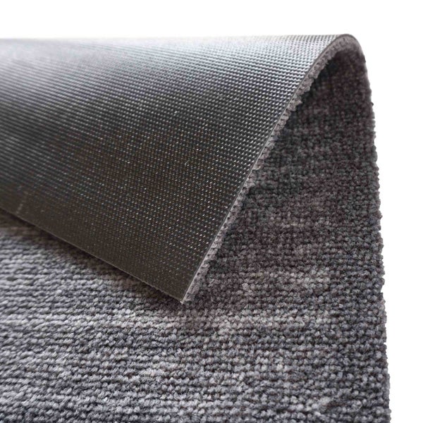 Detailansicht eines grauen Teppichs mit texturiertem Rücken