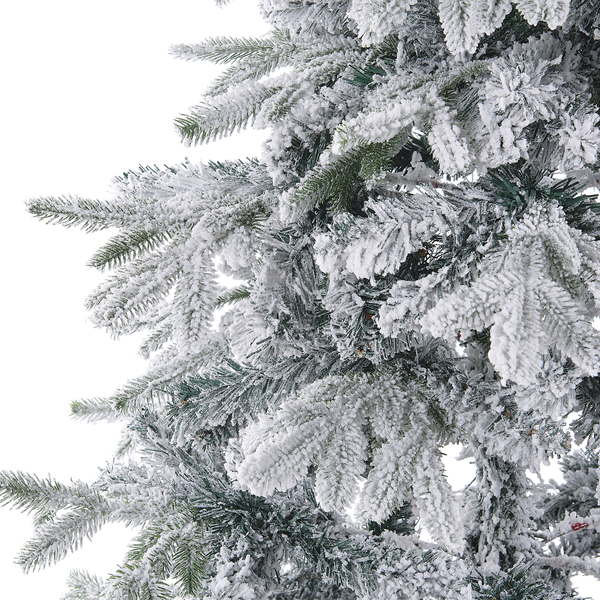 Nahaufnahme von künstlichen Tannenzweigen mit Kunstschnee bedeckt für einen Weihnachtsbaum.