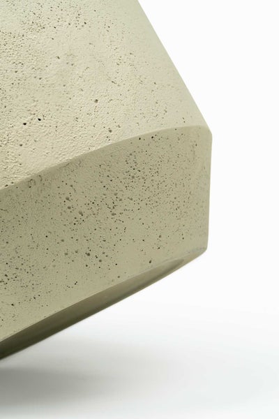 Detailaufnahme eines Pflanzgefäßes in Betonoptik mit poröser Oberflächenstruktur.