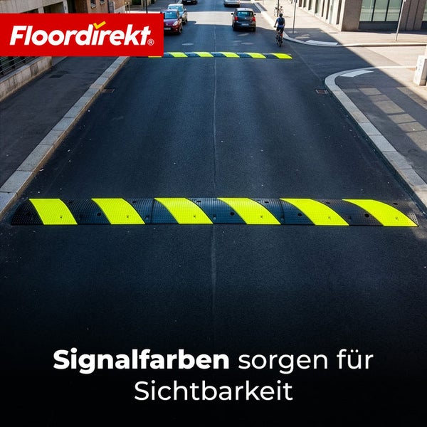 Fahrbahnschwelle mit schwarz-gelben Signalstreifen auf einer asphaltierten Straße zur Verkehrsberuhigung. Floordirekt Logo.