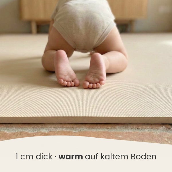 1 Zentimeter dicke Schaumstoff-Spielmatte für Kinder auf Steinboden mit einem krabbelnden Baby.