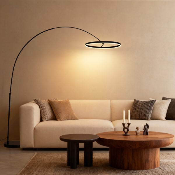 Schwarze Bogenlampe mit ringförmigem LED-Lichtelement über einem hellen Sofa im modernen Wohnzimmer.