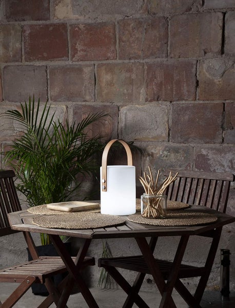 Dekorative Szene mit Tisch, Stühlen und einer tragbaren Lampe mit Griff