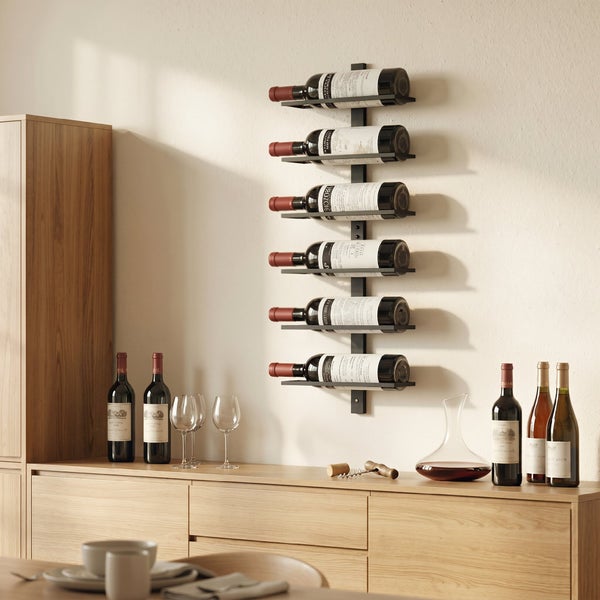 Wand-Weinregal aus Metall zur vertikalen Aufbewahrung von sechs Weinflaschen in einem modernen Wohnraum mit Holzkommode.
