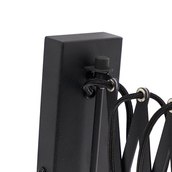 Detail einer schwarzen Gelenkarmleuchte mit Textilkabel