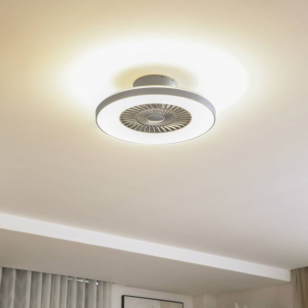 Moderner, runder Deckenventilator mit integriertem LED-Lichtring an der Zimmerdecke montiert und eingeschaltet.