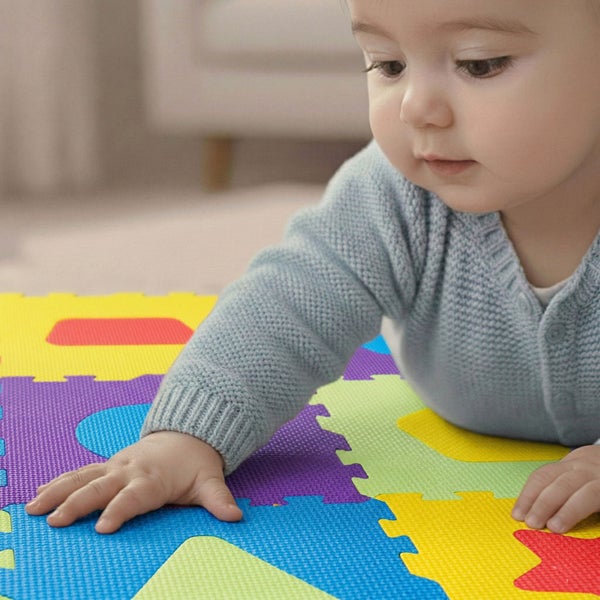 Kleinkind auf einer bunten Puzzle-Spielmatte aus Schaumstoff mit verschiedenen geometrischen Formen und strukturierter Oberfläche.