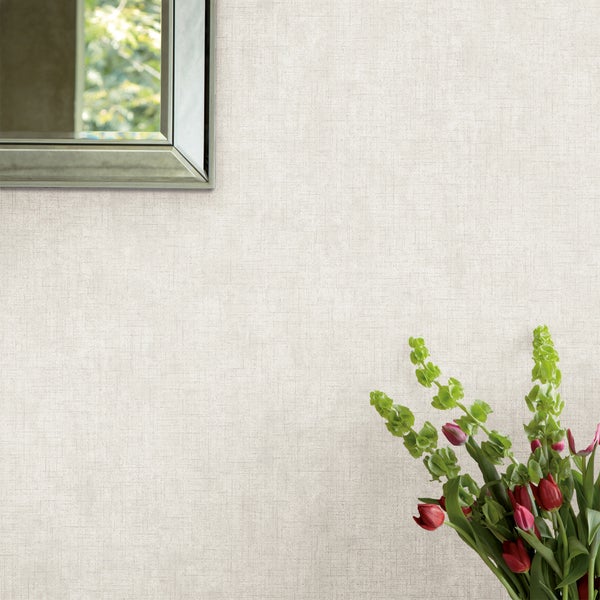 Strukturierte Tapete mit feiner Weboptik auf einer Wand, dekoriert mit einem Wandspiegel und einem Blumenstrauß.