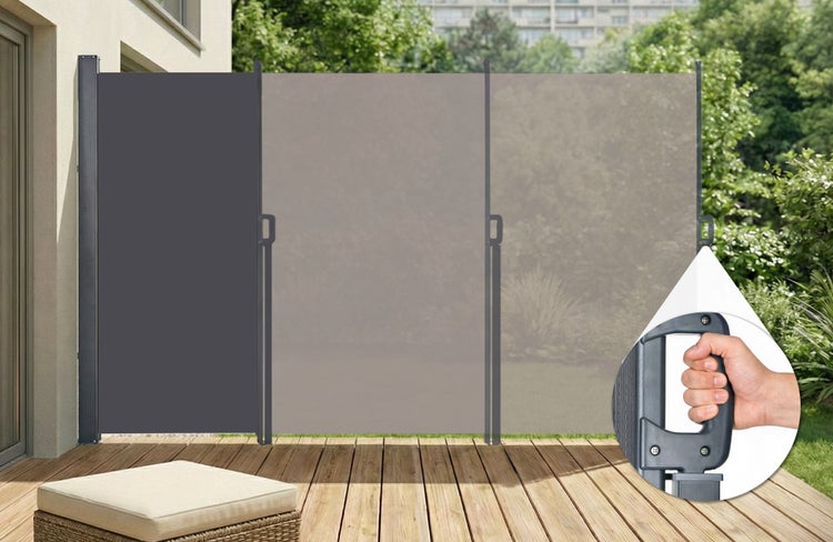 Graue ausziehbare Seitenmarkise auf einer Holzterrasse als Sicht- und Windschutz, mit Metallgestell und Detailansicht des ergonomischen Griffs.