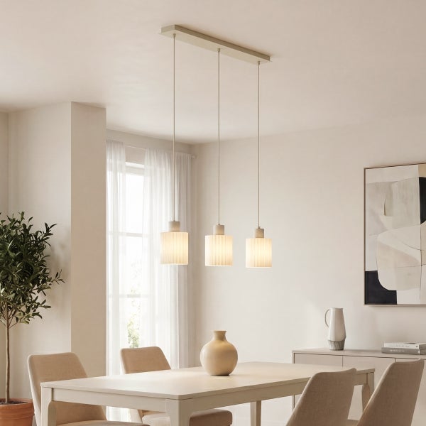 Dreiflammige Pendelleuchte mit geriffelten, zylindrischen Schirmen über einem Esstisch in einem hellen, modern eingerichteten Esszimmer.