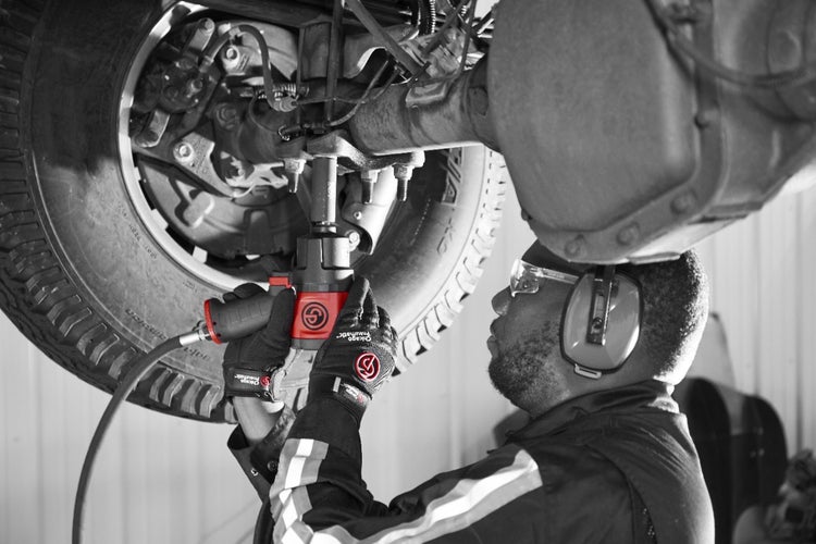 Mechaniker arbeitet mit einem Schlagschrauber an einem Fahrzeug.