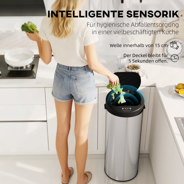 Frau in moderner Küche beim Verwenden eines automatischen Sensor Abfalleimers mit Edelstahloberfläche für hygienische Abfallentsorgung.