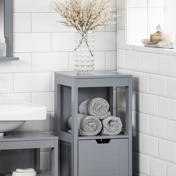 Grauer Badezimmerschrank mit Handtüchern und Dekoration im Badezimmer.