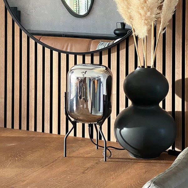 Dekoratives Wohnzimmer mit Tischleuchte, Vase und Spiegel