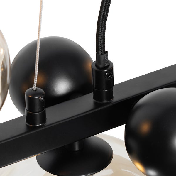 Detailansicht einer schwarzen Hängeleuchte mit runden Lampenschirmen und Kabelaufhängung.