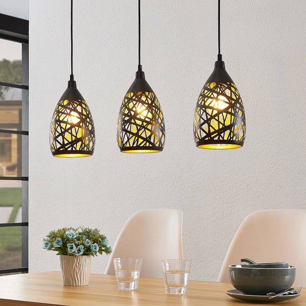 Dreiflammige Pendelleuchte mit schwarzen Gitterschirmen und goldener Innenseite, über einem hellen Esstisch in einem organisierten Raum.