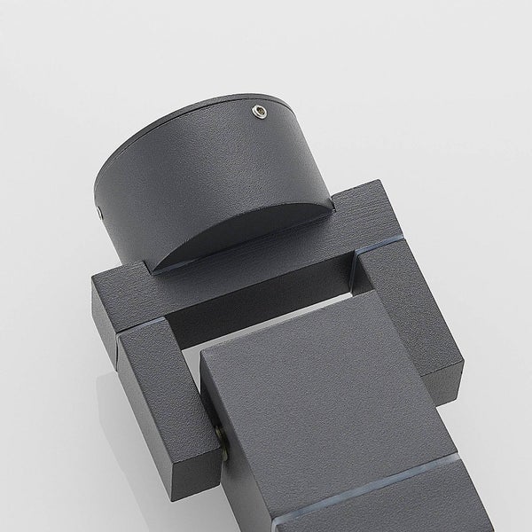 Schwarze Tischleuchte mit Stativfuß und Rattanschirm auf einem Tisch.