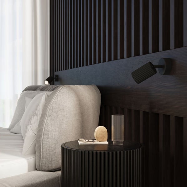 Schlafzimmer mit Bett, Nachttisch und Wandleuchten für eine gemütliche Atmosphäre.