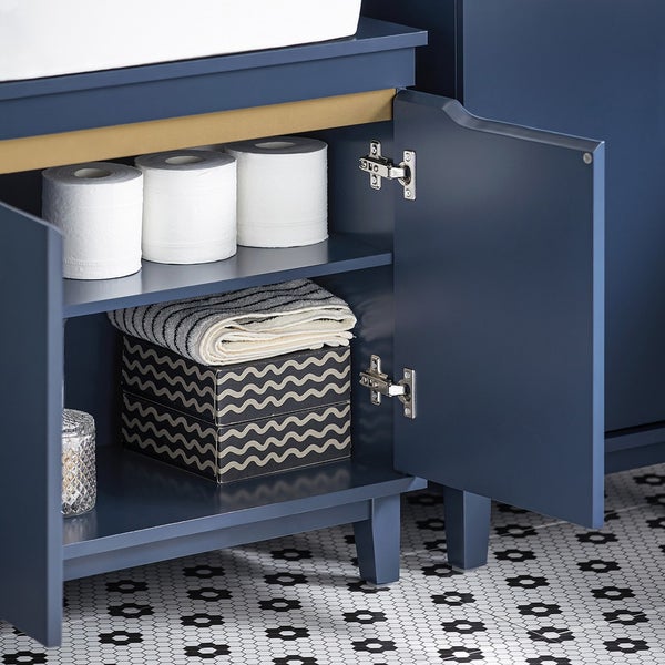 Detailansicht eines Badezimmerschranks mit Toilettenpapier, Handtüchern und Dekorationsbox