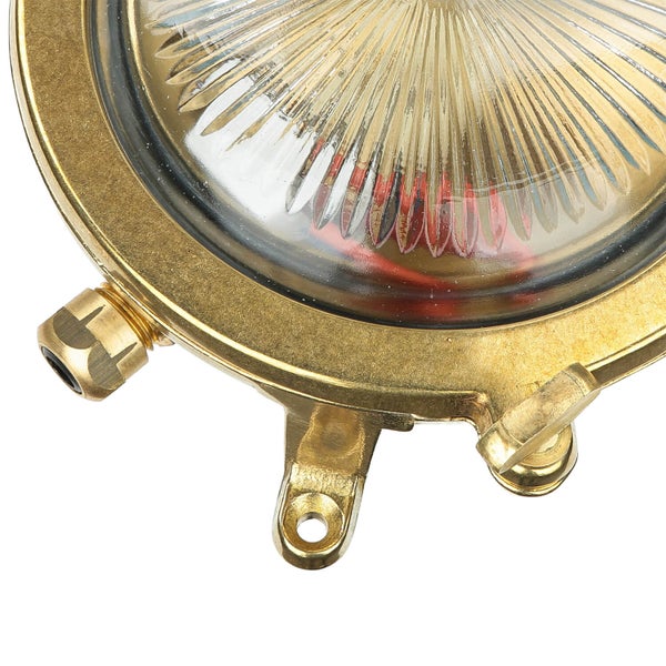 Detailansicht einer runden Messinglampe mit geriffeltem Glas