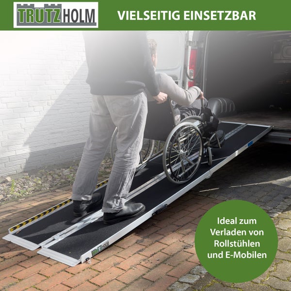 Eine Person schiebt einen Rollstuhl über eine zusammenklappbare Trutzholm Auffahrrampe in einen Transporter.