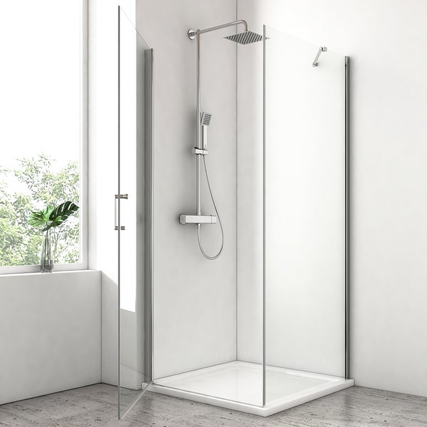 Moderne Duschkabine mit Glaselementen, verchromtem Duschsystem mit Regendusche und Handbrause sowie flacher Duschwanne in hellem Badezimmer.