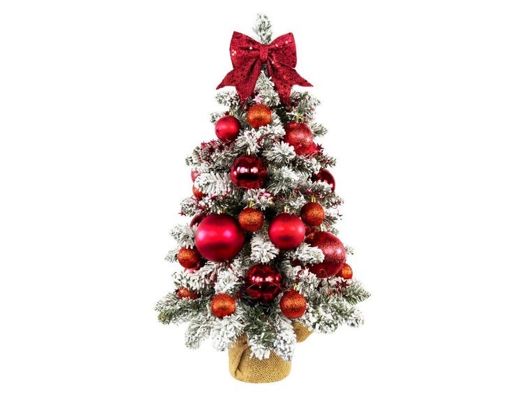 Künstlicher, beschneiter Weihnachtsbaum im Jutesack, dekoriert mit roten Weihnachtskugeln und einer großen Schleife als Spitze.