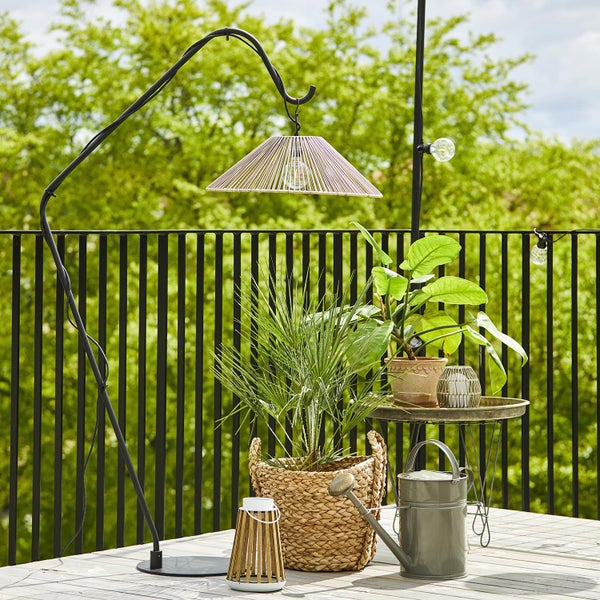 Außenbereich mit Bogenleuchte, Pflanzen und Tisch auf einer Terrasse