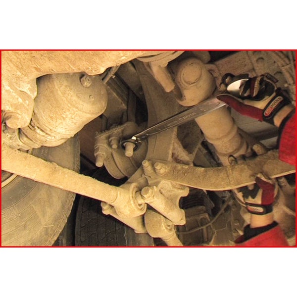 Eine Person benutzt einen Schraubenschlüssel an einem Fahrzeug.