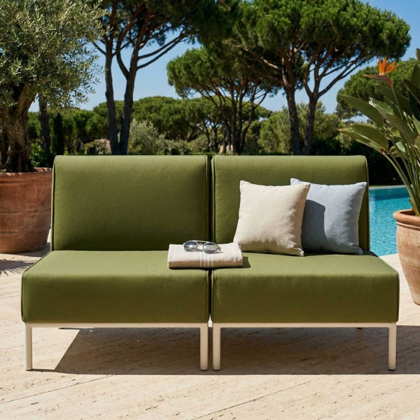 Modernes Outdoor-Sofa mit olivgrünen Polstern und weißem Gestell auf einer hellen Terrasse am Pool.