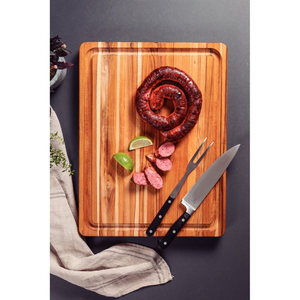 Holzschneidebrett mit Wurst, Messer und Gabel