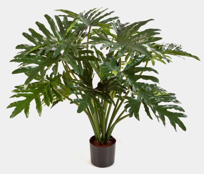 Künstlicher Philodendron mit großen, tief geschlitzten grünen Blättern in einem schwarzen Kunststofftopf.