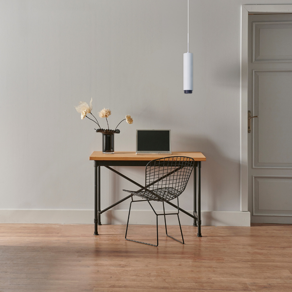 Schreibtisch mit Stuhl, Lampe, Laptop und Blumenvase in einem Arbeitszimmer.