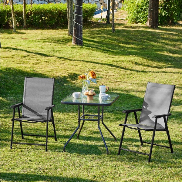 Gartenszene mit zwei Gartenstühlen und einem Tisch mit Glasplatte auf einer Rasenfläche
