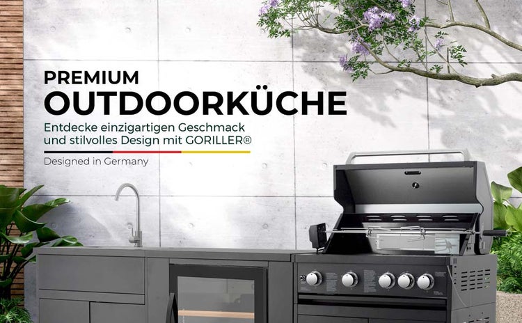 Moderne Goriller Outdoor-Küche aus Metall mit Gasgrill, Drehspieß, Spülbecken und Kühlschrank im Außenbereich.