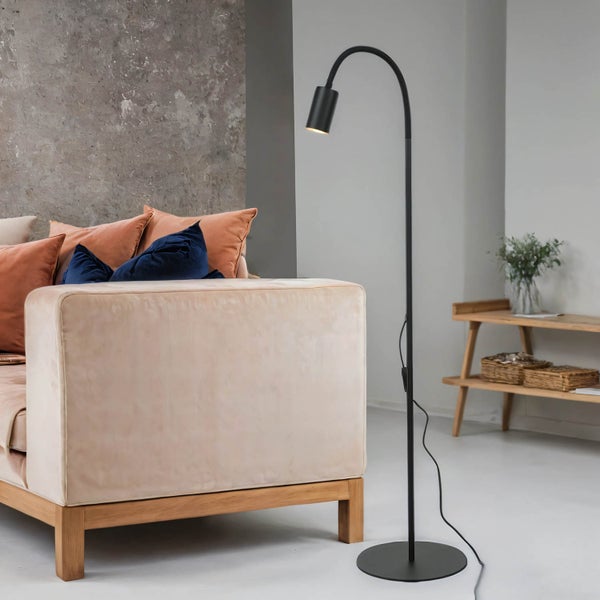 Wohnzimmer mit beigem Sofa, Kissen und schwarzer Stehlampe