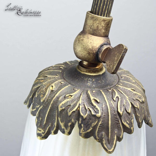 Detailaufnahme einer bronzefarbenen Leuchte mit floralem Dekor