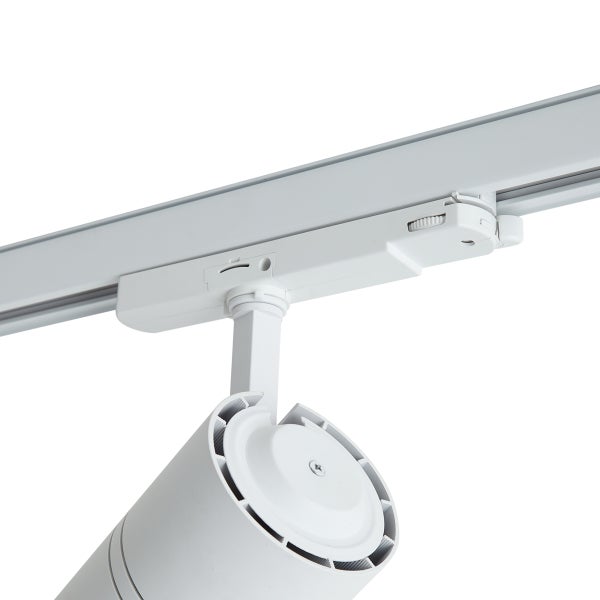 Weißer zylindrischer Strahler montiert an einem weißen Schienensystem.