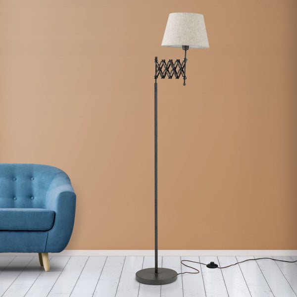 Stehlampe mit Scherenarm und Stoffschirm neben blauem Sofa