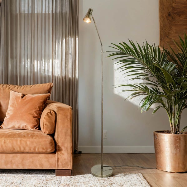 Wohnzimmer mit Sofa, Stehlampe und Zimmerpflanze im Topf