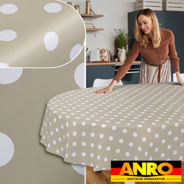 Runde Tischdecke mit weißem Punktmuster auf beigem Grund in einer Küche. ANRO DEUTSCHE MANUFAKTUR Logo.
