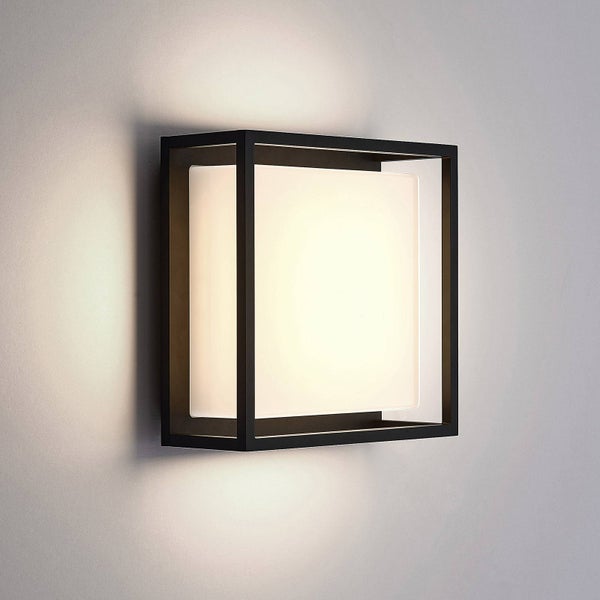 Moderne Außenwandleuchte mit quadratischem schwarzem Metallrahmen und weißem Lichtdiffusor, an einer Wand montiert.