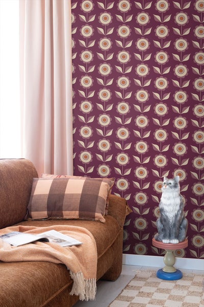 Wohnzimmer mit braunem Sofa, gemusterter Tapete und Dekofigur Katze