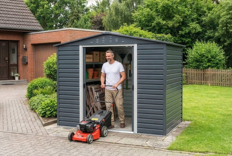 Metallgerätehaus in Anthrazit mit Satteldach und Schiebetür, organisiert mit Regalen und Gartengeräten in einer Gartenanlage.