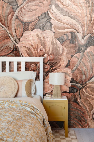 Dekoratives Schlafzimmer mit floraler Tapete, Nachttisch und Bett